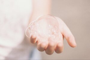 Close up of clean hand holding soap bubbles and foam