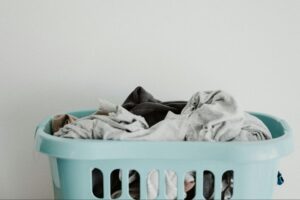 Light blue laundry basket filled with dirty clothes